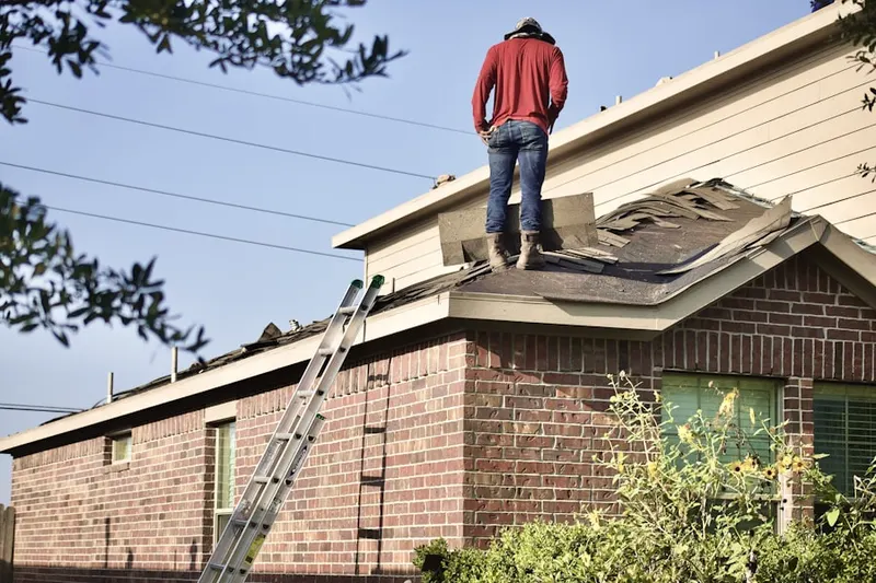Professional roofer working on a residential roof in Holladay